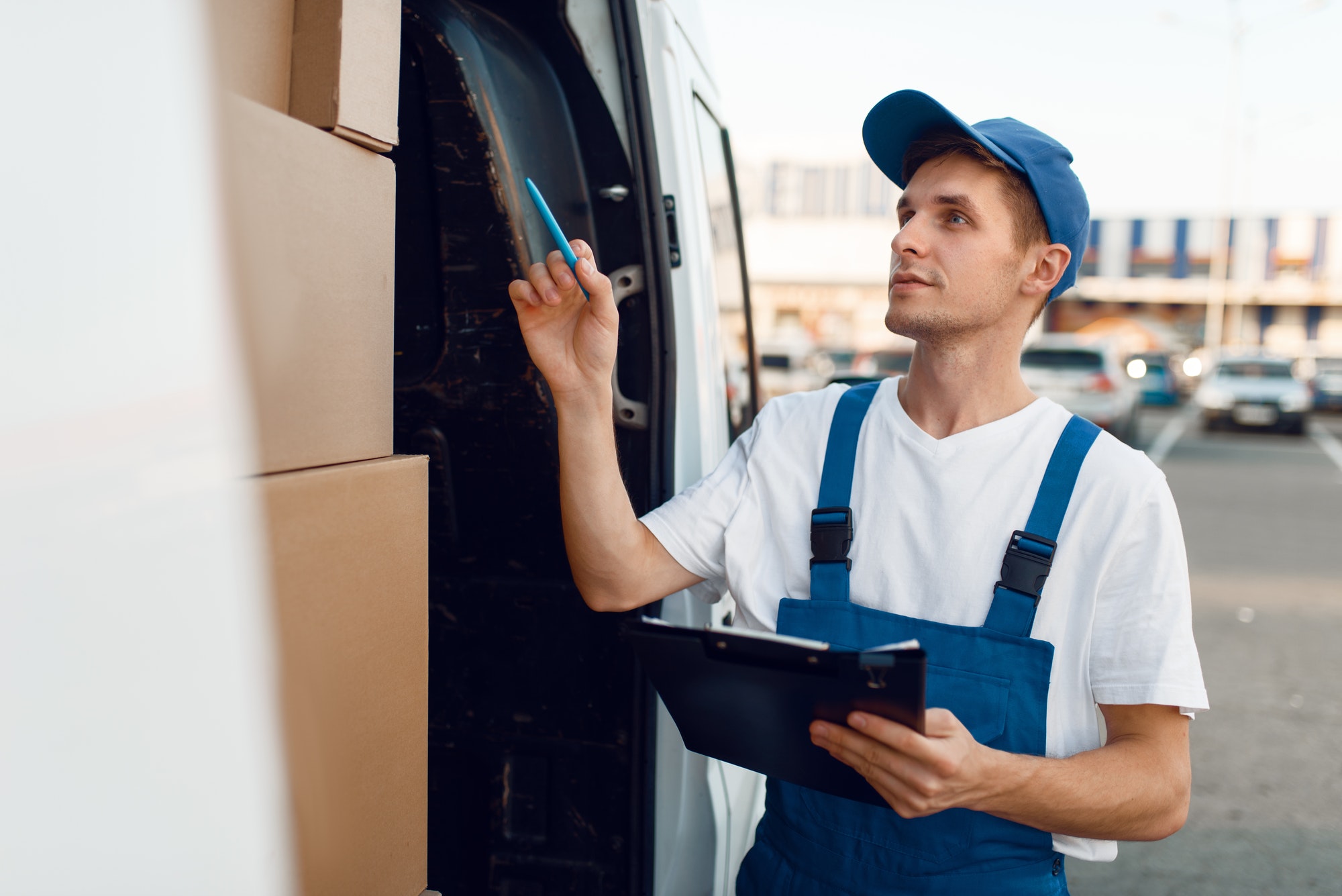 Deliveryman in uniform check boxes in the car